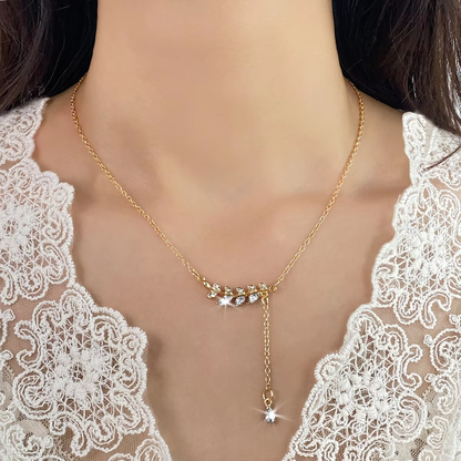 A gold-toned delicate necklace with a crescent moon and star pendant, worn by a model in a white lace top.