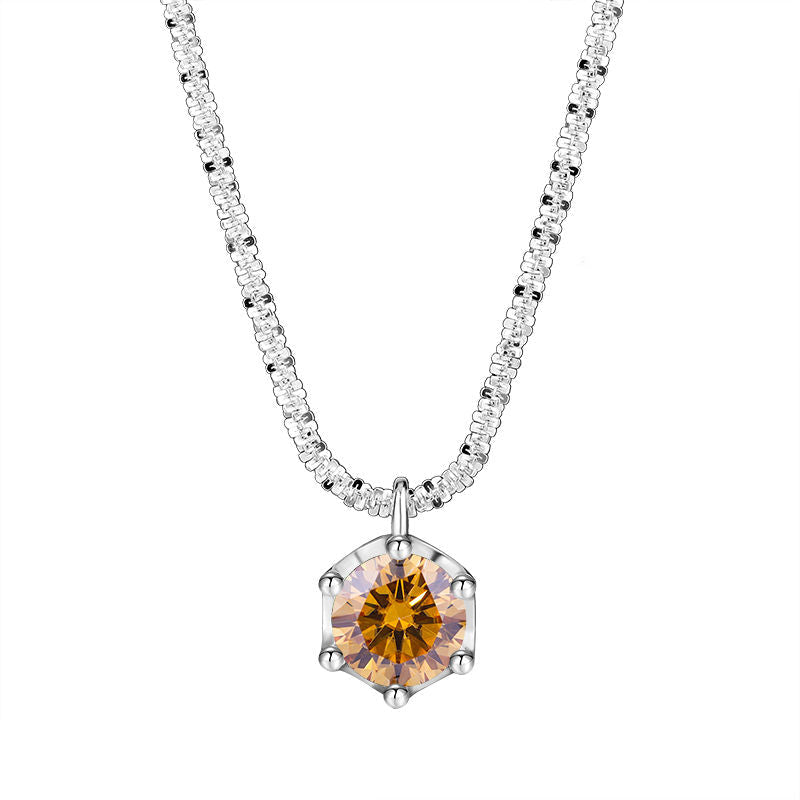 A silver-toned necklace featuring a hexagonal pendant with a faceted amber-orange center stone and clear surrounding stones on a white background, with the brand name NORELLE in the bottom left corner.