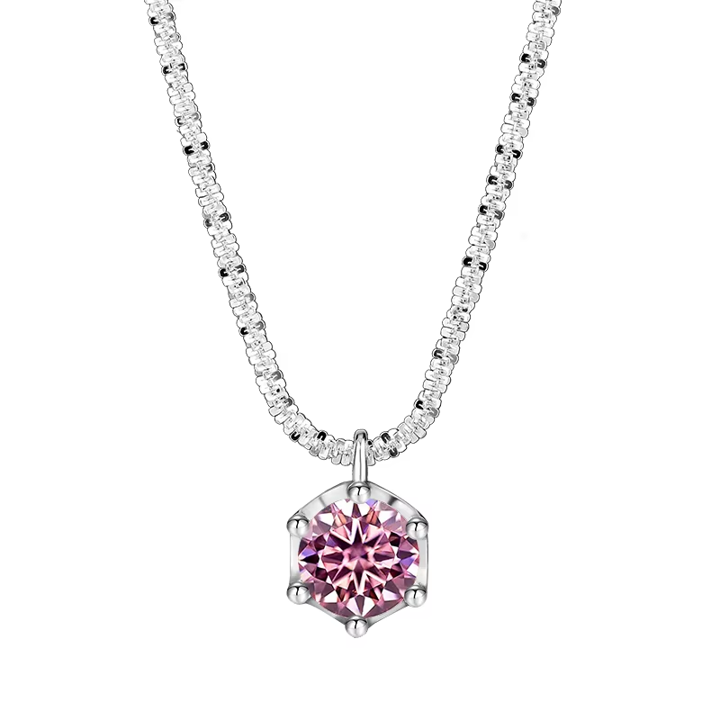 A silver-tone necklace featuring a hexagonal pendant with a faceted pink gemstone, set on a delicate pavé chain. The brand name 'NORELLE' is printed in black at the bottom left, all on a solid white background.