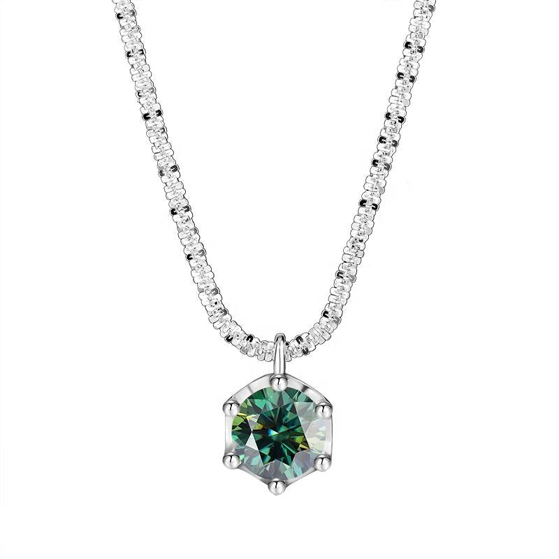 A silver-tone necklace featuring a hexagonal pendant with a faceted green gemstone, set on a delicate pavé chain. The brand name 'NORELLE' is printed in black at the bottom left, against a solid white background.